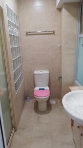 新加坡Property King的一间带粉红色卫生间和盥洗盆的浴室