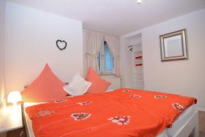 施马伦贝格Haus Oberkirchen的卧室配有橙色棉被,位于床上
