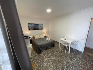 托莱多Alojamiento en el centro de Toledo的小房间设有一张床和一张桌子