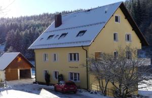 福尔巴赫Haus Gisela的一座黄色房子,屋顶雪盖