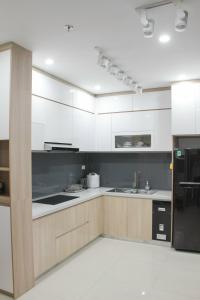 顺化Ly Homestay - Nera Garden Huế的厨房配有白色橱柜和黑色冰箱。