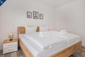 ZirchowAn der Haffküste Haffkoje的一间卧室配有带白色床单和毛巾的床。
