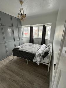 Enfield Lock30 min STN or to central London的一间卧室设有一张床、一个窗户和一个吊灯。