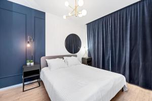 罗兹Lumina 2-room apartment with beautiful view Lodz的一间卧室配有一张带蓝色墙壁的大床
