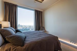 塔林Luxurious, Skyline View Apartment near Centre的一间卧室设有一张床和一个大窗户