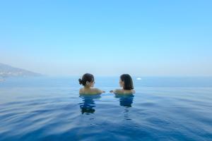 热海热海后乐园酒店(Atami Korakuen Hotel)的两个坐在海洋水中的女人