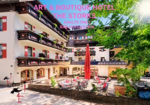 巴特霍夫加施泰因Hotel Bad Hofgastein - The STORKS - Adults Only - Bergbahnen bis November inklusive的前面设有桌椅的建筑