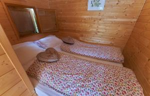 Obersteinbach阿尔萨斯村酒店的小木屋内一间卧室,配有两张床