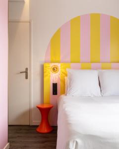 南特DEMAIN Hôtel & Conciergerie的一间卧室配有一张带色彩缤纷床头板的床