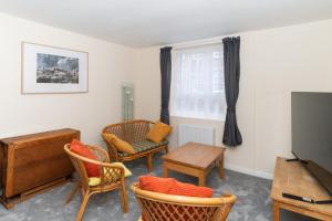 爱丁堡Brilliantly Located 2BD Flat Heart of Edinburgh!的客厅配有椅子、电视和桌子