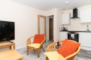 爱丁堡Brilliantly Located 2BD Flat Heart of Edinburgh!的客厅配有两把椅子和电视