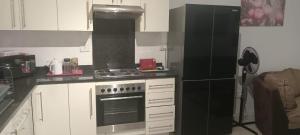 温特和克One bedroom self-catering apartment at CITY JUNCTION的厨房配有炉灶和黑冰箱。