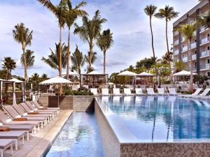 维雷亚凯悦集团威雷亚毛伊岛安达仕酒店的度假村的游泳池,设有躺椅和棕榈树