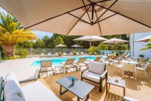 比斯卡罗斯海滩森林餐厅酒店的一个带桌椅和遮阳伞的游泳池