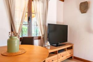 法塔加Casa Simón的客厅配有一张桌子,木柜上配有电视