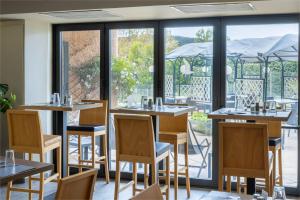 拉瓦雷特迪瓦尔Noemys Toulon La Valette - Hotel restaurant avec piscine的一间带桌椅的餐厅以及一个阳台