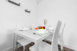 伯明翰Smethwick Deluxe 2 Bedroom Aparetment - Secure Parking - Balcony - Rated Exceptional - 9MC的白色餐桌和白色椅子