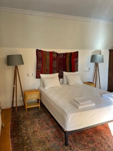 卡斯Kale Lodge - Adult Only + 15的卧室配有带两盏灯和地毯的白色床。