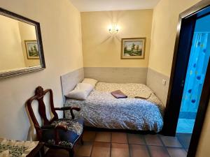 比拉夫洛尔Hotel Rural Vilaflor Self check in 24h的一间小卧室,配有一张床和一把椅子