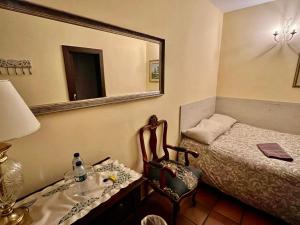 比拉夫洛尔Hotel Rural Vilaflor Self check in 24h的一间卧室配有一张床、镜子和椅子