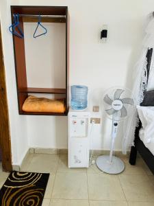 乌昆达Tulivu Suites Diani的客房配有风扇和小冰箱。