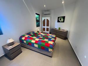 阿尔比恩O’ Paradis D’Albion的一间卧室配有一张色彩缤纷的床和2个床头柜。
