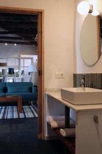 乌鲁埃尼亚La Real Urueña的一间带水槽和镜子的浴室和一间客厅