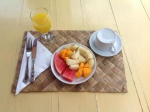 特特巴图Nea Cottage Lombok的桌上的水果盘,加上一杯橙汁