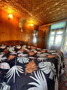 斯利那加Pasadona Floating Houseboat的一间卧室配有一张带花卉图案的毯子的大床