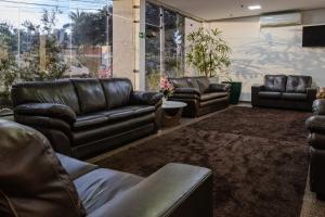 戈亚尼亚Allegro Hotel的客厅配有真皮沙发和椅子