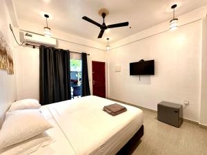 图杜Thoddoo Island Life的一间卧室配有一张床和吊扇