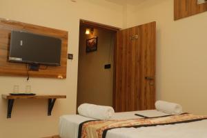 瓦拉纳西De Classico Hotel的客房设有两张床和一台平面电视。
