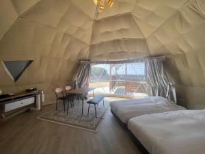 淡路8point resort Awaji的一间设有两张床的房间和一张帐篷内的桌子