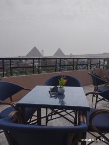 开罗Sneferu Pyramids inn - Full Pyramids View的美景阳台配有桌椅