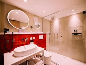 萨尔茨堡artHotel Blaue Gans的一间带水槽、淋浴和镜子的浴室