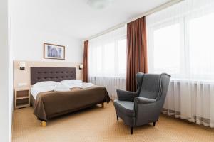 华沙Hotel Logos的一间卧室配有一张床和一把椅子