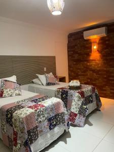 雅帕拉廷加Pousada Villa Minduba的一间卧室配有两张床,床上有被子