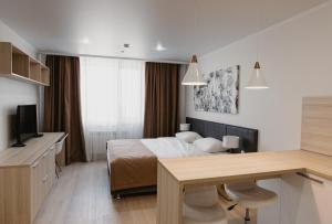 阿斯塔纳YE'S Астана的酒店客房配有一张床、一张书桌和一台电视。