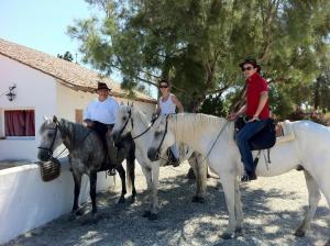 圣马迪拉莫卡夏尔酒店的三人在房子前骑马