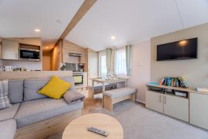 佩文西30 Bayside Cove Pevensey Bay Holiday Park的带沙发的客厅和厨房