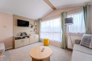 佩文西30 Bayside Cove Pevensey Bay Holiday Park的客厅配有沙发和桌子