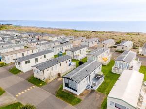 佩文西30 Bayside Cove Pevensey Bay Holiday Park的海洋旁一排房子的空中景观