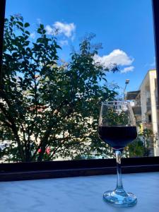 库塔伊西Moedani-Very Center Apartments in Kutaisi的坐在窗前桌子上的一杯葡萄酒