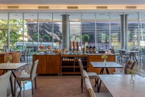 亚松森Tryp by Wyndham Asuncion的餐厅设有桌椅和窗户。