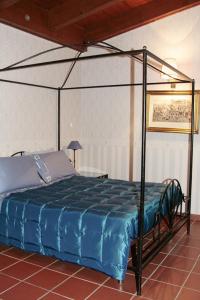 阿夸维瓦德莱丰蒂Masseria Mofetta的一间卧室配有一张带蓝色棉被的天蓬床
