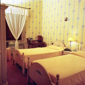 阿夸维瓦德莱丰蒂Masseria Mofetta的一间设有两张床铺的卧室,位于带壁纸的房间