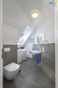 万根沃格Bootshaus in den Duenen - 5 Bootshaus in den Duenen Wangerooge - 5的浴室配有白色卫生间和盥洗盆。