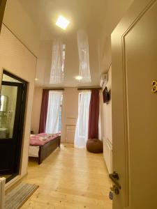 库塔伊西Moedani-Very Center Apartments in Kutaisi的带走廊、床和窗户的客房