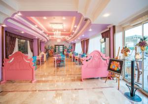 基兹洛特Armas Pemar Beach的配有粉红色和蓝色椅子和桌子的房间