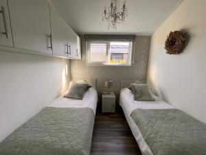 博文卡尔斯佩尔Vakantie Villa Markermeer的小型客房设有两张单人床和窗户。